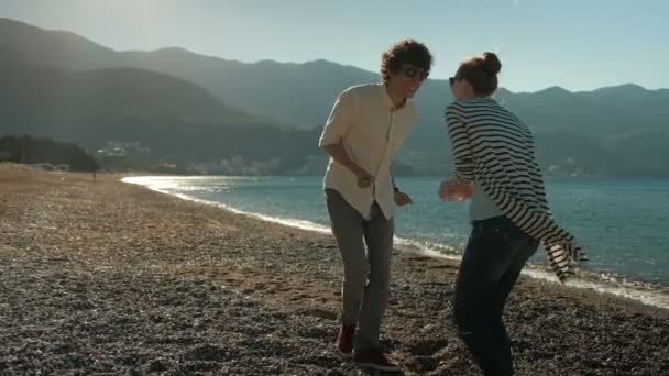 Пара веселых танцев на закате на пляже . — стоковое видео