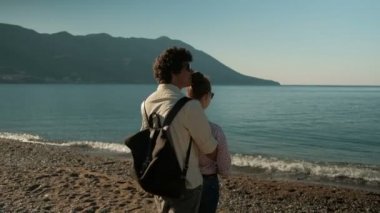 Sahil üzerinde duran kadın ve erkek birbirlerine nestle.