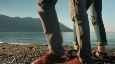 Güneşli bir günde shingle Plajı deniz kenarında sevgi dolu çift yürü.