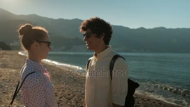 Mladý pár stojí na úložišti písečné moře v létě. — Stock video