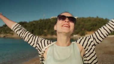 Genç kadın eğleniyor kıyısında güneşli günde.