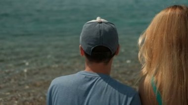 Yaz günü açık havada sahilde oturan genç Çift.