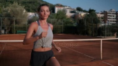 Genç kadın bir tenis maçı açık mahkemede önce pratik.