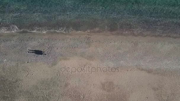 Молодая пара прогуливается вдоль берега моря в летний день на открытом воздухе . — стоковое видео
