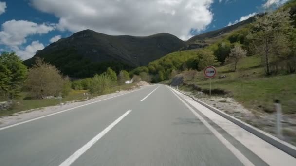 Voiture se déplace le long de la route de banlieue dans la journée d'été. Véhicule conduit rapidement sur la route . — Video