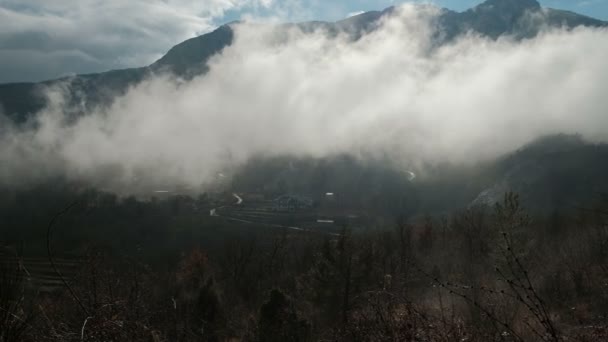 Le brouillard épais enveloppe la vallée avec un grisonnement parmi les montagnes . — Video
