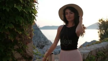 Esmer kadın deniz ve kayalar karşı flört büyüleyici yaz aylarında.