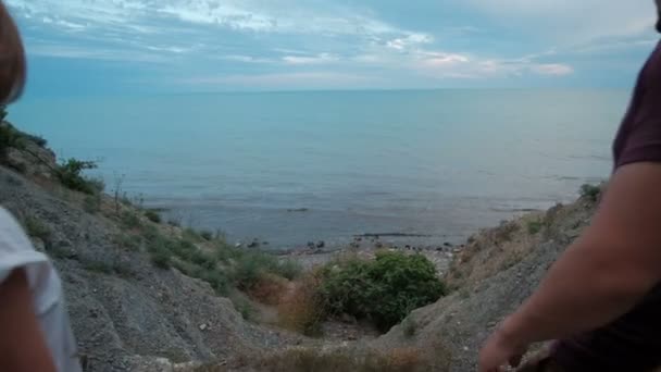 Young woman and man go to sea shore on summer evening outdoors. — Stock Video