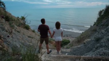 Genç çift shore tarafından dur ve yaz günü açık denize bakmak.
