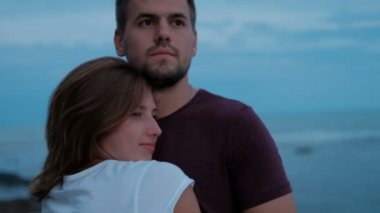 Gökyüzüne karşı mesafe bakarak ve sarılma sevgi dolu Çift.