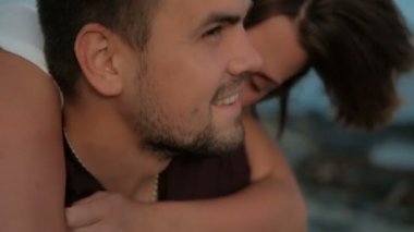 Genç bir çift deniz kıyısında yaz akşamı açık vakit.