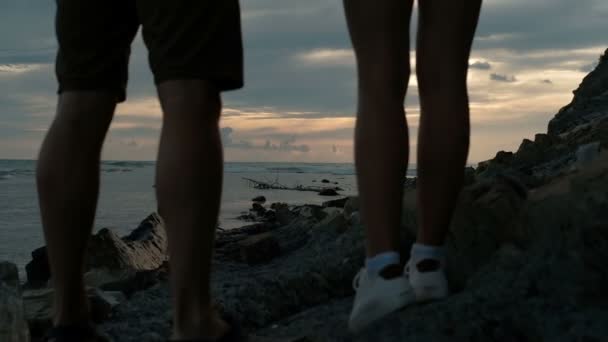 Άνδρας και γυναίκα, κρατήστε τα χέρια και το απόγευμα βλέποντας το ηλιοβασίλεμα στη θάλασσα. — Αρχείο Βίντεο