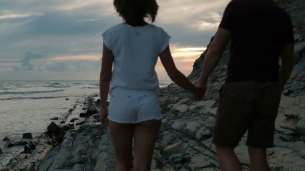 Pareja joven caminando a lo largo de la costa en verano noche al aire libre . — Vídeo de stock