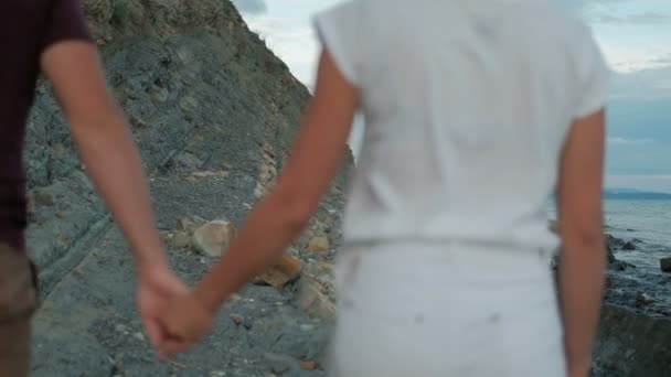 Joven hombre y mujer caminando a lo largo de la orilla del mar en la noche de verano al aire libre . — Vídeos de Stock