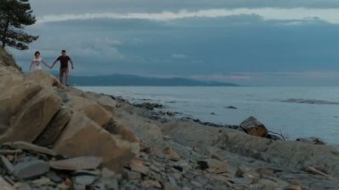 Genç adam ve deniz kıyısı açık havada yaz akşam çalışan kadın.