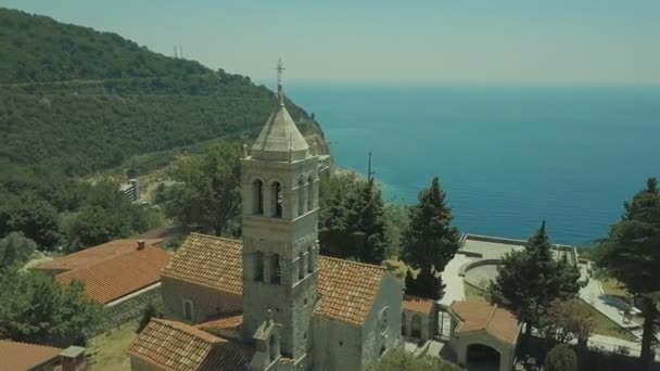 Aus arischer Sicht. Katholische Kathedrale in einer kleinen Stadt, eine Kirche aus weißem Stein am Meer im Sommer. — Stockvideo