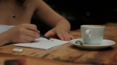 Genç kadın coffee House masada oturan çizim.