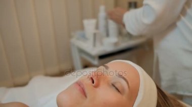 Kozmetik kliniğinde kapalı kapalı gözler ile genç bir kadın yatıyor.