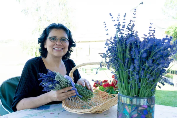 Medelålders kvinna arrangera lavendel blombukett — Stockfoto