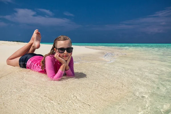 带着太阳眼镜躺在热带海滩上的女孩 — 图库照片