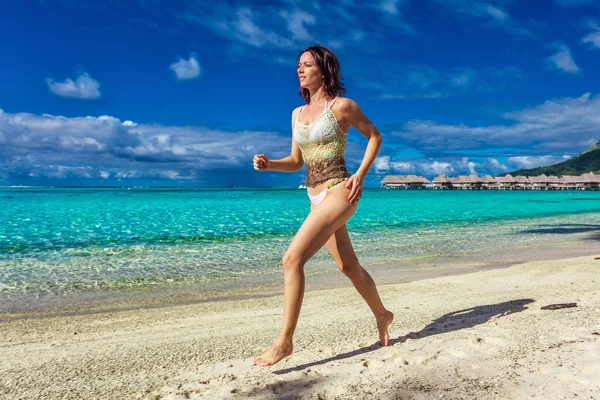 Γυναίκα που τρέχει σε τροπική παραλία — Φωτογραφία Αρχείου