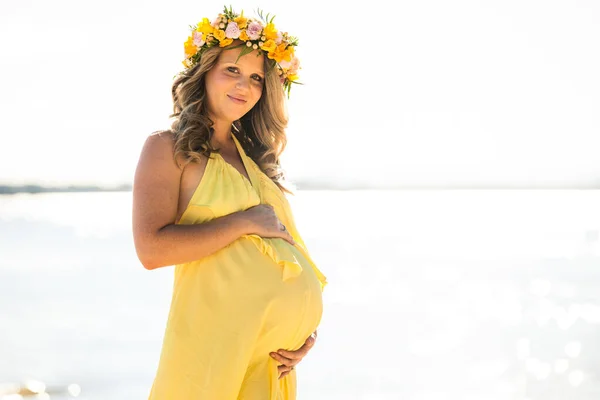 Щаслива вагітна жінка з довгим волоссям на сонячний день, пляж і р — стокове фото