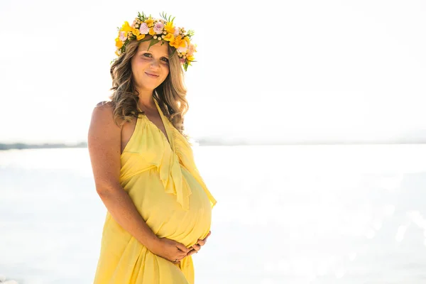 Glückliche schwangere Frau mit langen Haaren an einem sonnigen Tag, Strand und Strand — Stockfoto