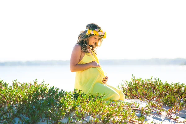Счастливая беременная женщина с длинными волосами в солнечный день, пляж и р — стоковое фото