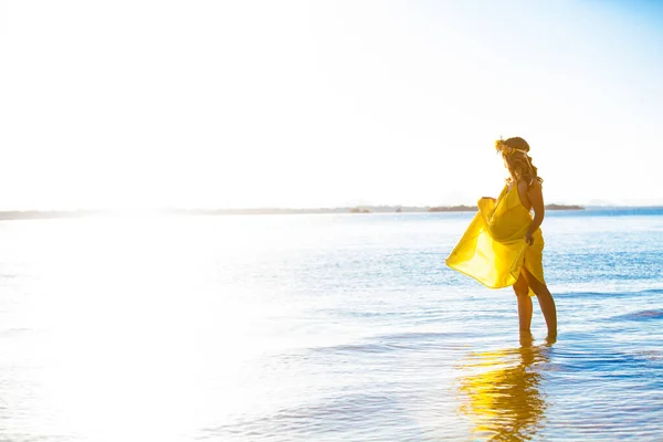 Glückliche schwangere Frau mit langen Haaren an einem sonnigen Tag, Strand und Strand — Stockfoto
