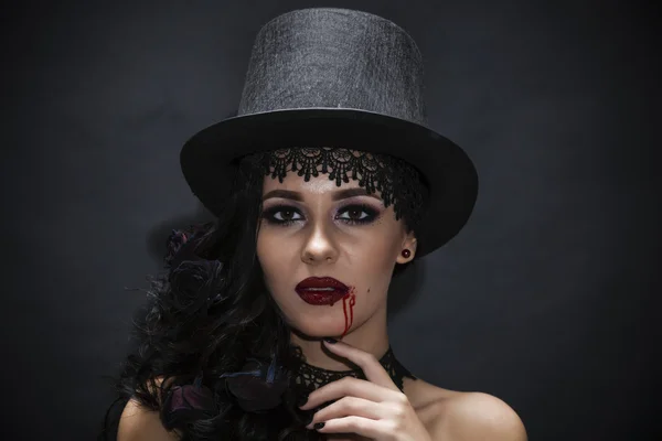 Πορτρέτο της μια πανέμορφη μελαχρινή με ένα καπέλο σε μαύρο φόντο — Φωτογραφία Αρχείου