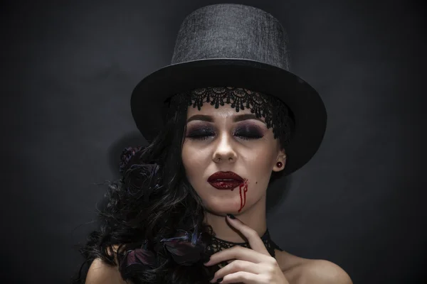 Ritratto di una splendida bruna con un cappello su sfondo nero — Foto Stock