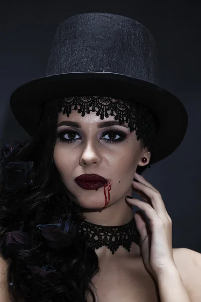 Πορτρέτο της μια πανέμορφη μελαχρινή με ένα καπέλο σε μαύρο φόντο — Φωτογραφία Αρχείου