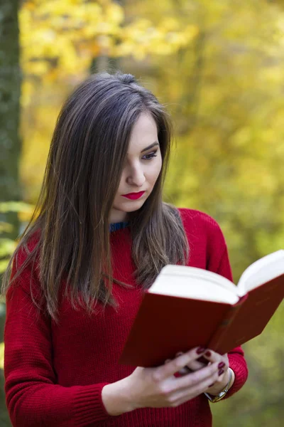 Portret van mooie jonge brunette meisje het lezen van een boek in de — Stockfoto