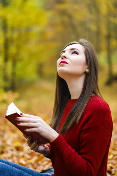 Portret van mooie jonge brunette meisje het lezen van een boek in de — Stockfoto