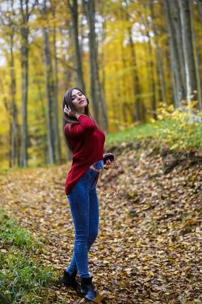 Young caucasian brunette woman with headphones outdoors on autum — Stock Photo, Image