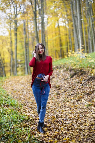 Young caucasian brunette woman with headphones outdoors on autum — Stock Photo, Image