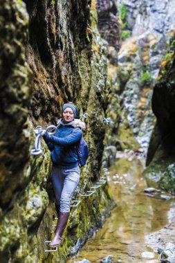 Kadın çok dar bir gorg Emanet zincirleri üzerinde tırmanma uzun yürüyüşe çıkan kimse
