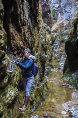Kadın çok dar bir gorg Emanet zincirleri üzerinde tırmanma uzun yürüyüşe çıkan kimse