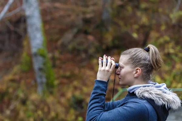 若いブロンドの女性観光双眼鏡を通して見る崖の上 — ストック写真