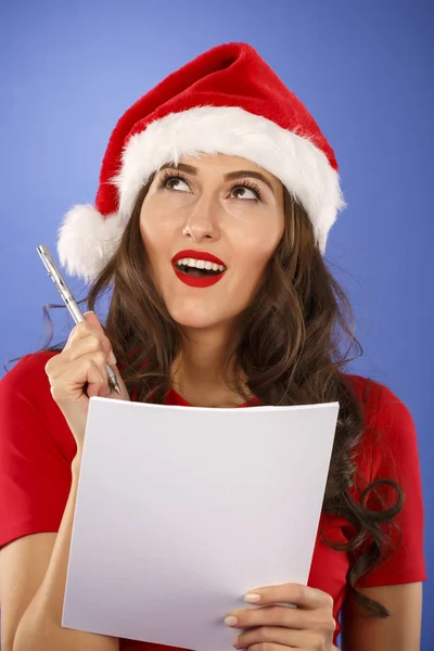 Žena s vánoční čepice se seznamem v ruce — Stock fotografie