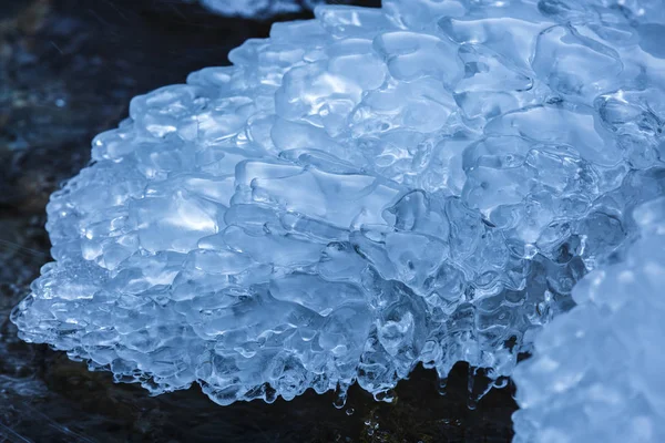 Primer plano de un río congelado de montaña que fluye a través de rocas heladas —  Fotos de Stock