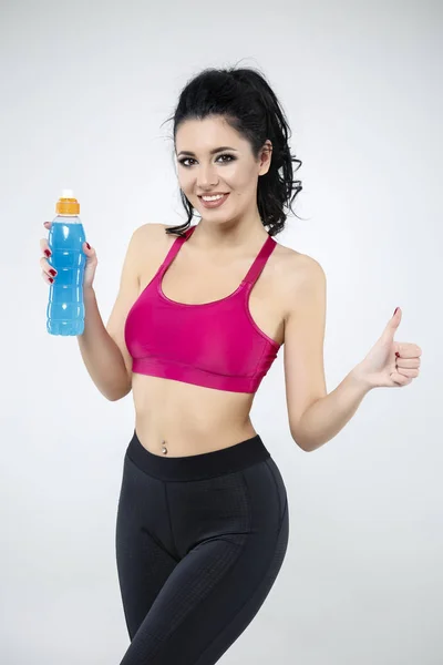 Attractive woman drinking water from bottle after exercise — Stock Photo, Image