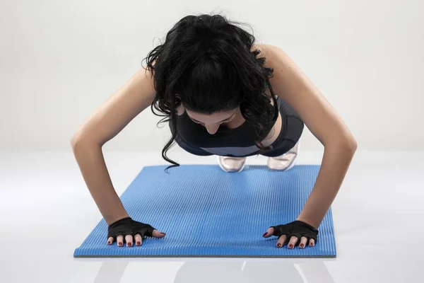 Bela mulher magra fazendo exercícios de alongamento no tapete de ioga isol — Fotografia de Stock