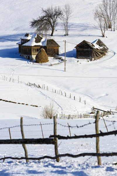 Paesaggio invernale con un villaggio di montagna in Romania — Foto Stock