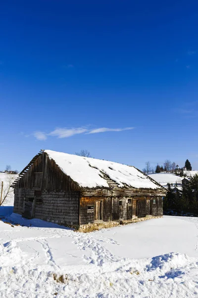 Antigua casa de madera en el paisaje de invierno, Rumania —  Fotos de Stock