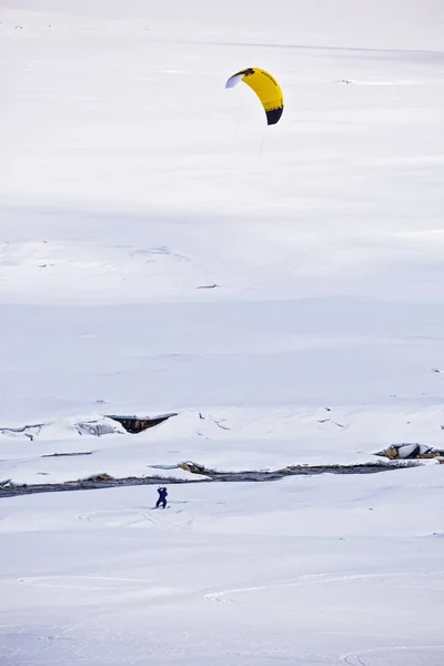 Gente haciendo kitesurf en un lago de montaña congelado — Foto de Stock