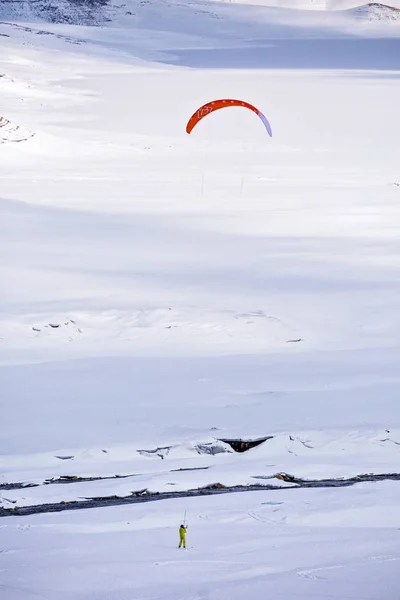 凍った山の湖でカイトサーフィンをしている人たちは — ストック写真