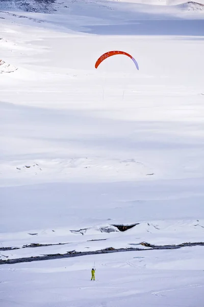 Gente haciendo kitesurf en un lago de montaña congelado — Foto de Stock