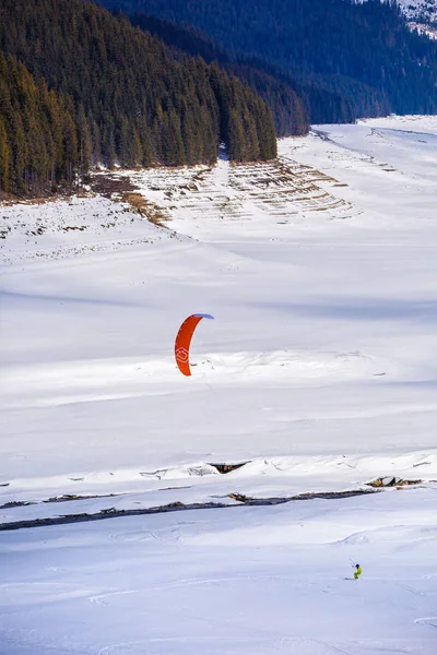 Gente haciendo kitesurf en un lago de montaña congelado — Foto de Stock