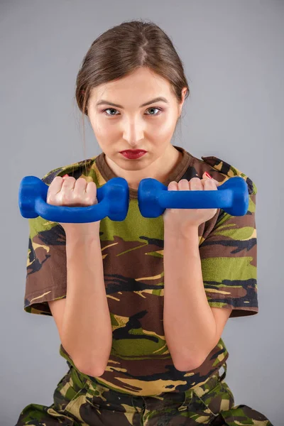 Una modelo de fitness femenina deportiva vestida con un camuflaje militar h — Foto de Stock